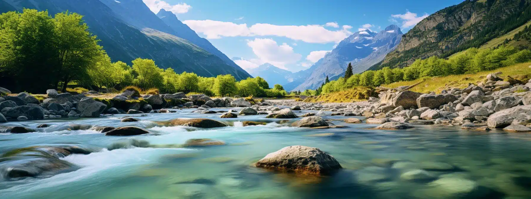A Clear, Flowing River Running Through A Picturesque Mountainscape.