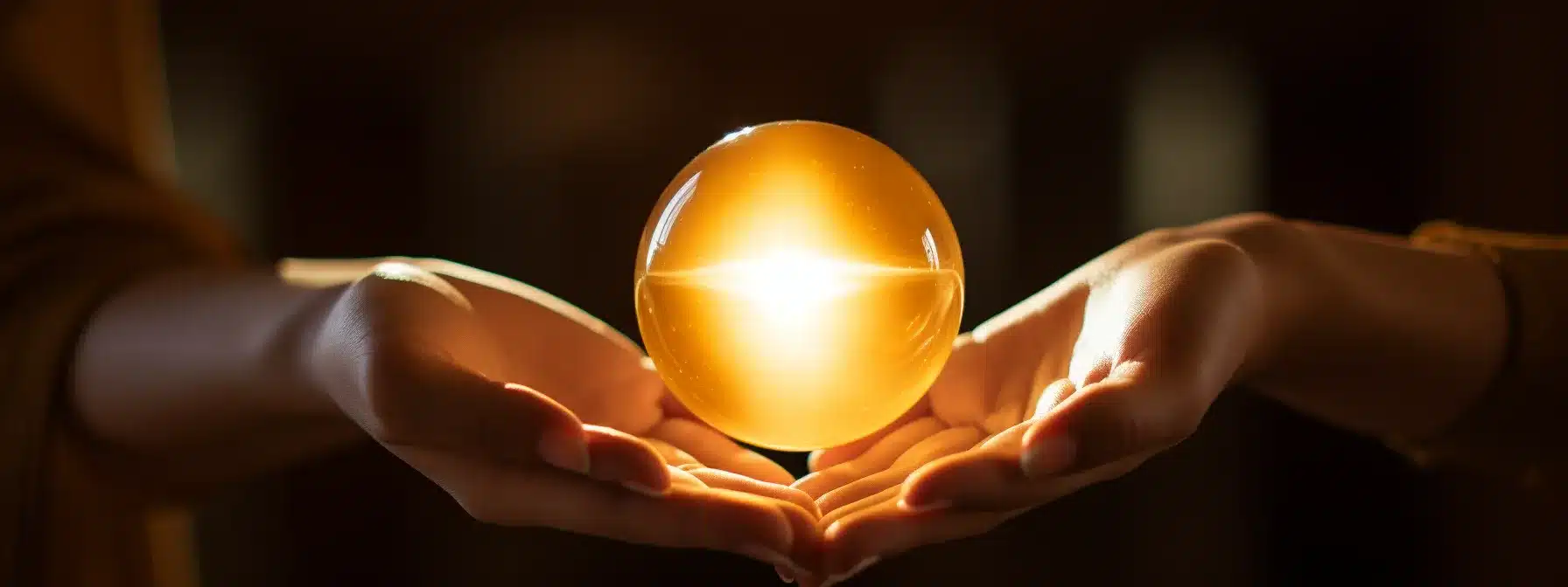 A Person Holding A Golden Pearl In Their Hand.
