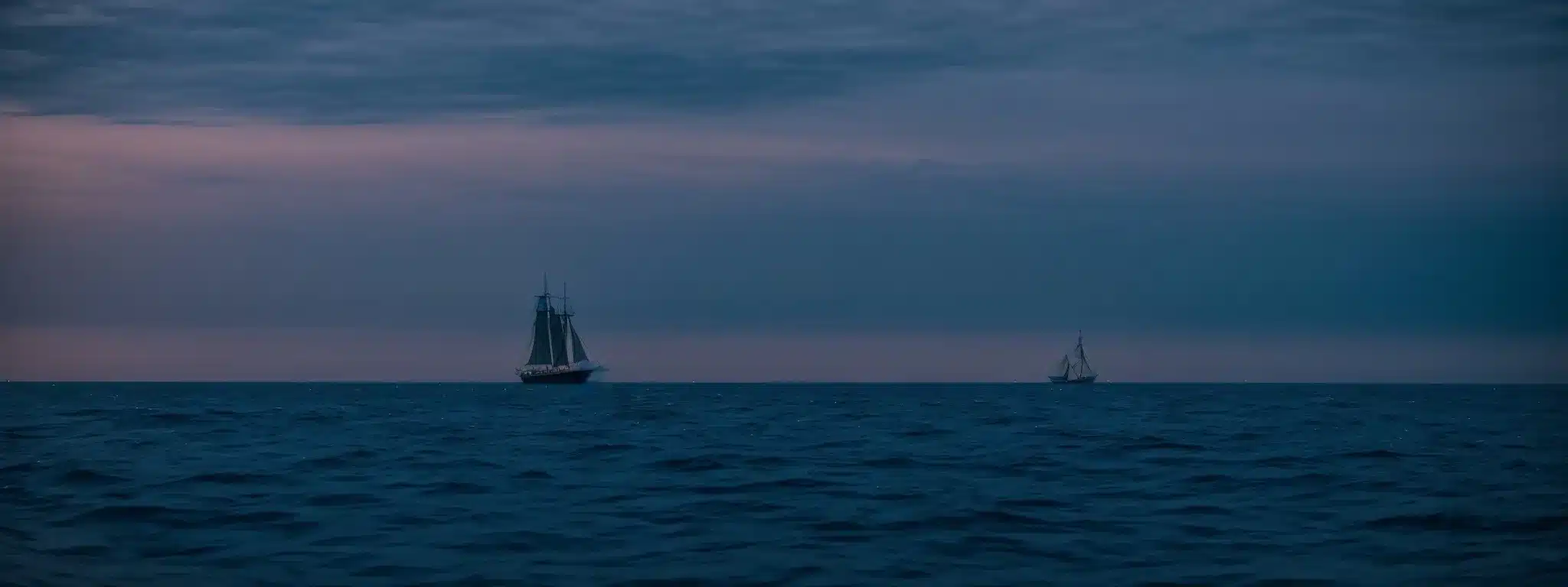 A Sailing Ship On The Open Sea At Twilight, With A Clear View Stretching Towards A Horizon Glowing With The Last Light Of Day.