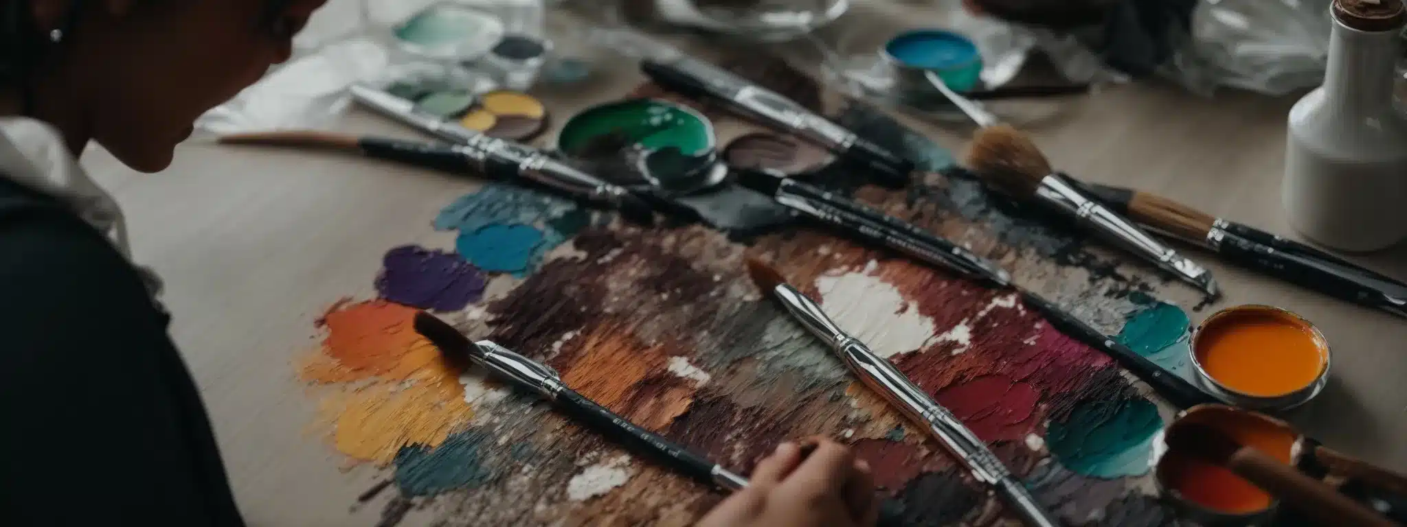 An Artist Dips Their Brush Into A Vibrant Palette, Poised To Transform A Blank Canvas Into A Masterpiece.