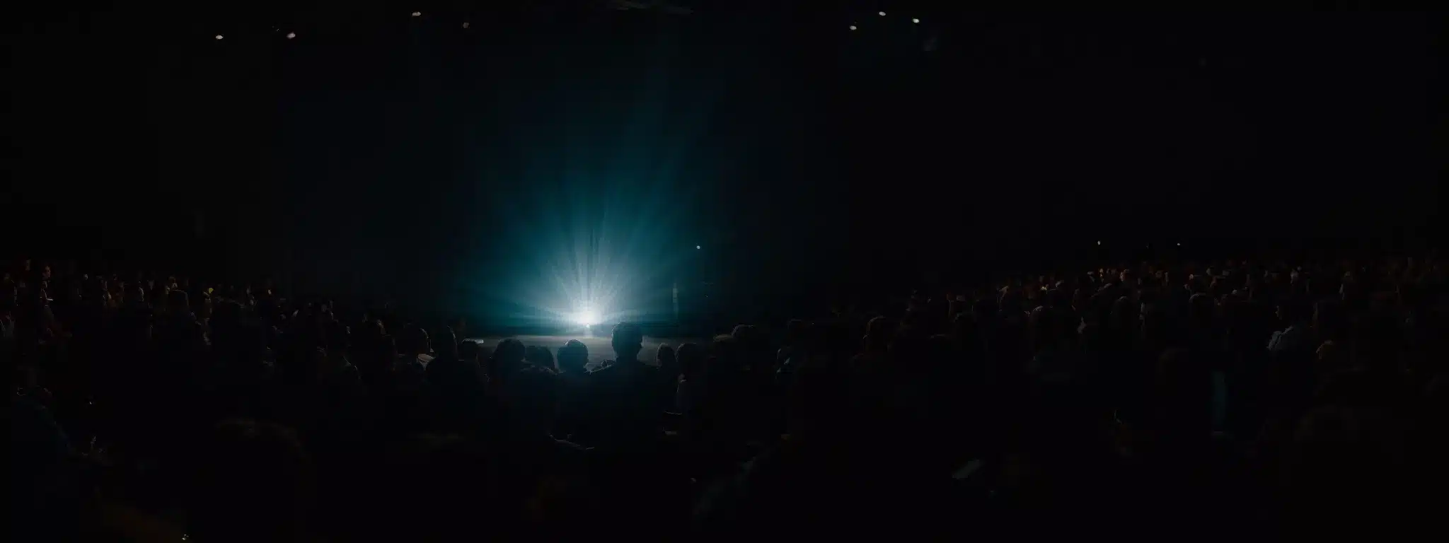 A Spotlight Illuminating A Standout Product On A Stage While A Shadowed Audience Watches In Anticipation.