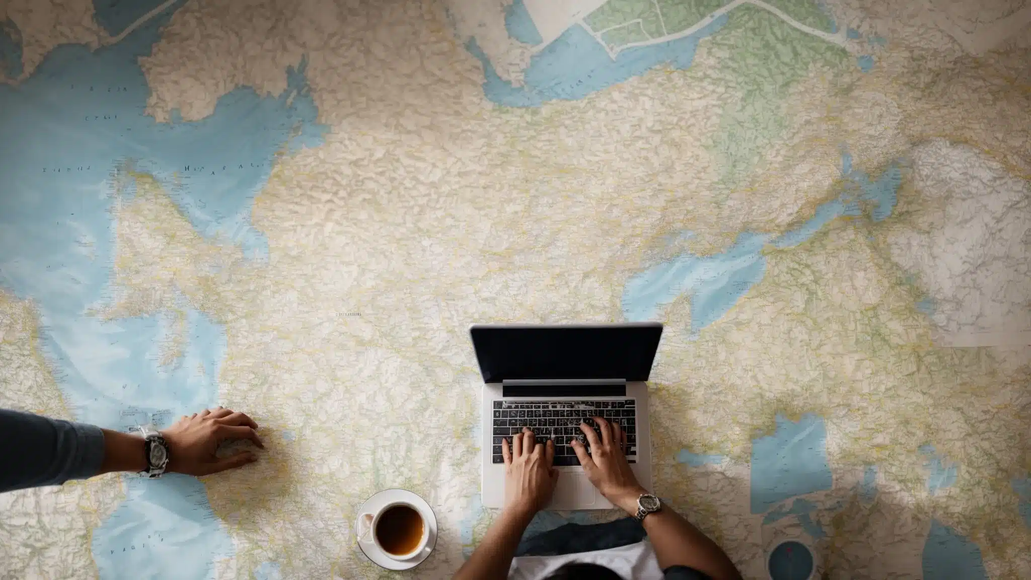 a person types on a laptop surrounded by maps and local landmarks, highlighting targeted areas for seo strategy.
